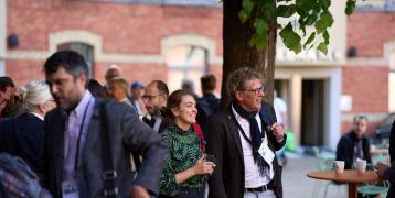 Two people standing in a courtyard smiling